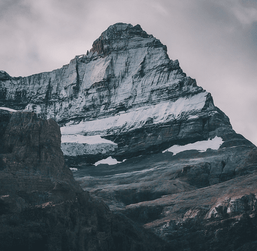 Imagen of A close-up photo of a mountain peak, showcasing the dramatic contrast between snow-capped summit and rugged rock face